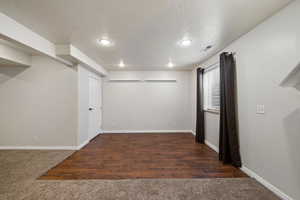 Spare room featuring dark hardwood / wood-style flooring and a textured ceiling