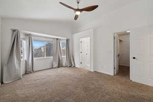 Unfurnished bedroom with vaulted ceiling, a spacious closet, ceiling fan, and connected bathroom