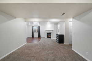 Unfurnished living room featuring carpet flooring and a textured ceiling