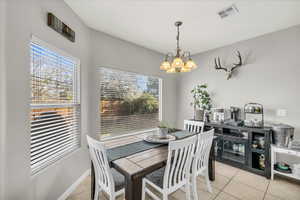 Tiled dining area with an inviting chandelier