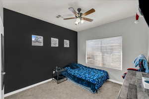 Carpeted bedroom featuring ceiling fan