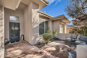 View of exterior entry with a patio area