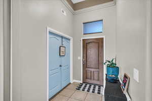 Entryway featuring a towering ceiling and light tile patterned flooring