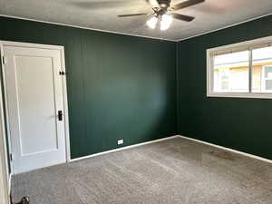 Bedroom 1 with large slider window and ceiling fan