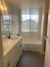 Bathroom featuring cooling unit, a tub, and vanity