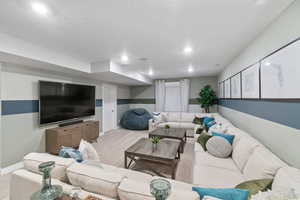 Carpeted living room with a textured ceiling