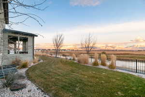 Yard at dusk with a water and mountain view and a rural view