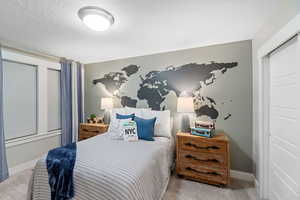 Carpeted bedroom featuring a textured ceiling