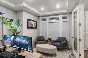 Interior space with a tray ceiling, french doors, and hardwood / wood-style flooring