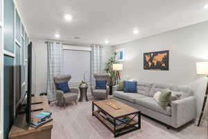 Carpeted living room featuring a textured ceiling