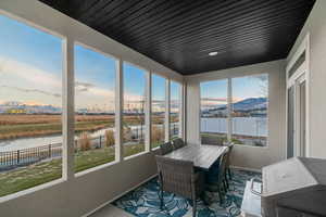 Sunroom featuring a water and mountain view