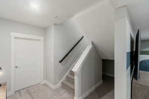 Stairway featuring carpet and a textured ceiling