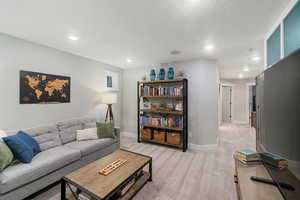 Carpeted living room featuring a textured ceiling