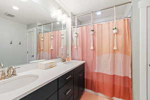 Bathroom with a shower with curtain, tile patterned flooring, and vanity