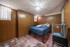 Bedroom featuring wooden walls