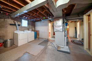 Basement with heating unit and washer and clothes dryer