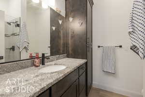 Bathroom with hardwood / wood-style floors, vanity, and walk in shower