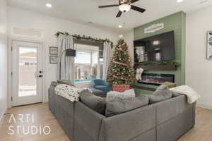 Living room with ceiling fan, a fireplace, and light hardwood / wood-style floors