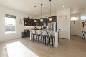 Kitchen with plenty of natural light, dark brown cabinets, and appliances with stainless steel finishes