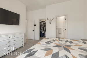 Carpeted bedroom featuring connected bathroom, a spacious closet, and a closet