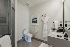 Bathroom with vanity, toilet, and an enclosed shower