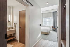 Hallway featuring a barn door and light hardwood / wood-style floors