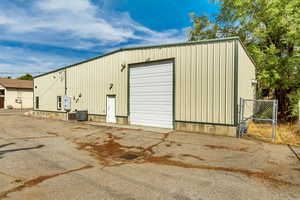 View of outdoor structure with central AC unit and a garage