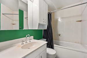 Full bathroom with shower / bath combination with curtain, vanity, and toilet