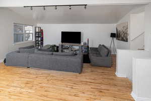 Living room featuring light hardwood / wood-style floors and vaulted ceiling