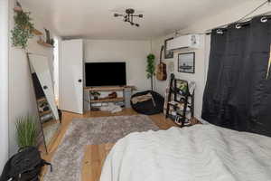 Bedroom with a wall mounted air conditioner and light wood-type flooring