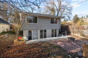 Rear view of property featuring a patio area and a fire pit