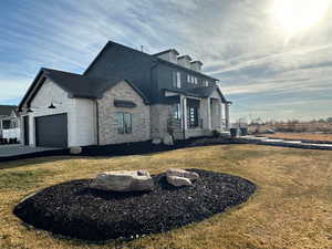 View of side of property with a lawn and a garage