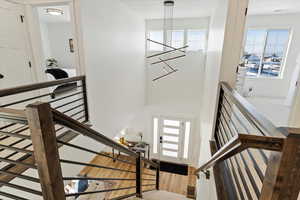 Stairway featuring hardwood / wood-style floors and a chandelier