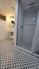 Bathroom featuring tile patterned floors, sink, toilet, and a shower with shower curtain