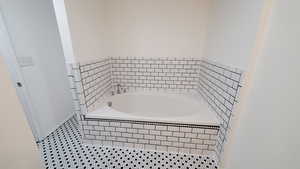 Bathroom featuring tile patterned floors and tiled tub