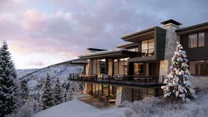 Snow covered property with a mountain view and a balcony