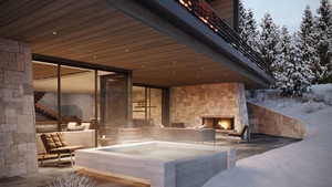 Snow covered patio featuring an outdoor stone fireplace