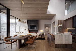 Dining area featuring a fireplace, a towering ceiling, light hardwood / wood-style floors, and expansive windows