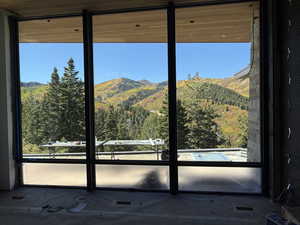 Doorway featuring a mountain view and a wooded view