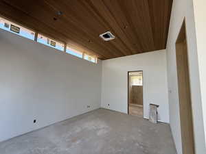 Spare room with wooden ceiling and unfinished concrete floors