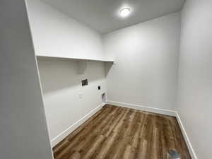 Laundry area with hookup for an electric dryer, wood-type flooring, and washer hookup