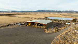 Drone / aerial view with a water and mountain view and a rural view