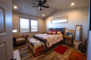 Bedroom with vaulted ceiling, ceiling fan, and dark wood-type flooring