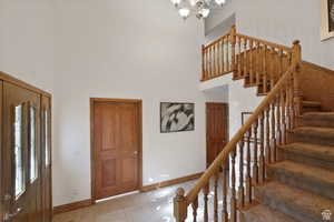 Entryway with a chandelier, a high ceiling, and light tile patterned flooring