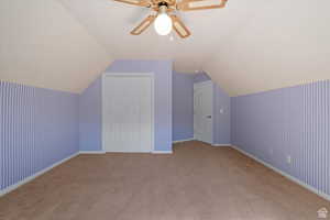 Bonus room with carpet, vaulted ceiling, and ceiling fan