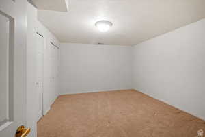 Spare room with light colored carpet and a textured ceiling