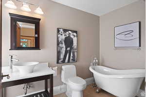 Bathroom featuring tile patterned floors, sink, a bath, and toilet