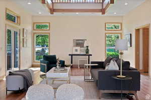 Living room with french doors, hardwood / wood-style floors, and a high ceiling