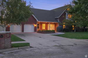 View of front of property with a garage and a yard