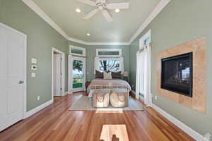 Bedroom with light wood-type flooring, ceiling fan, and crown molding